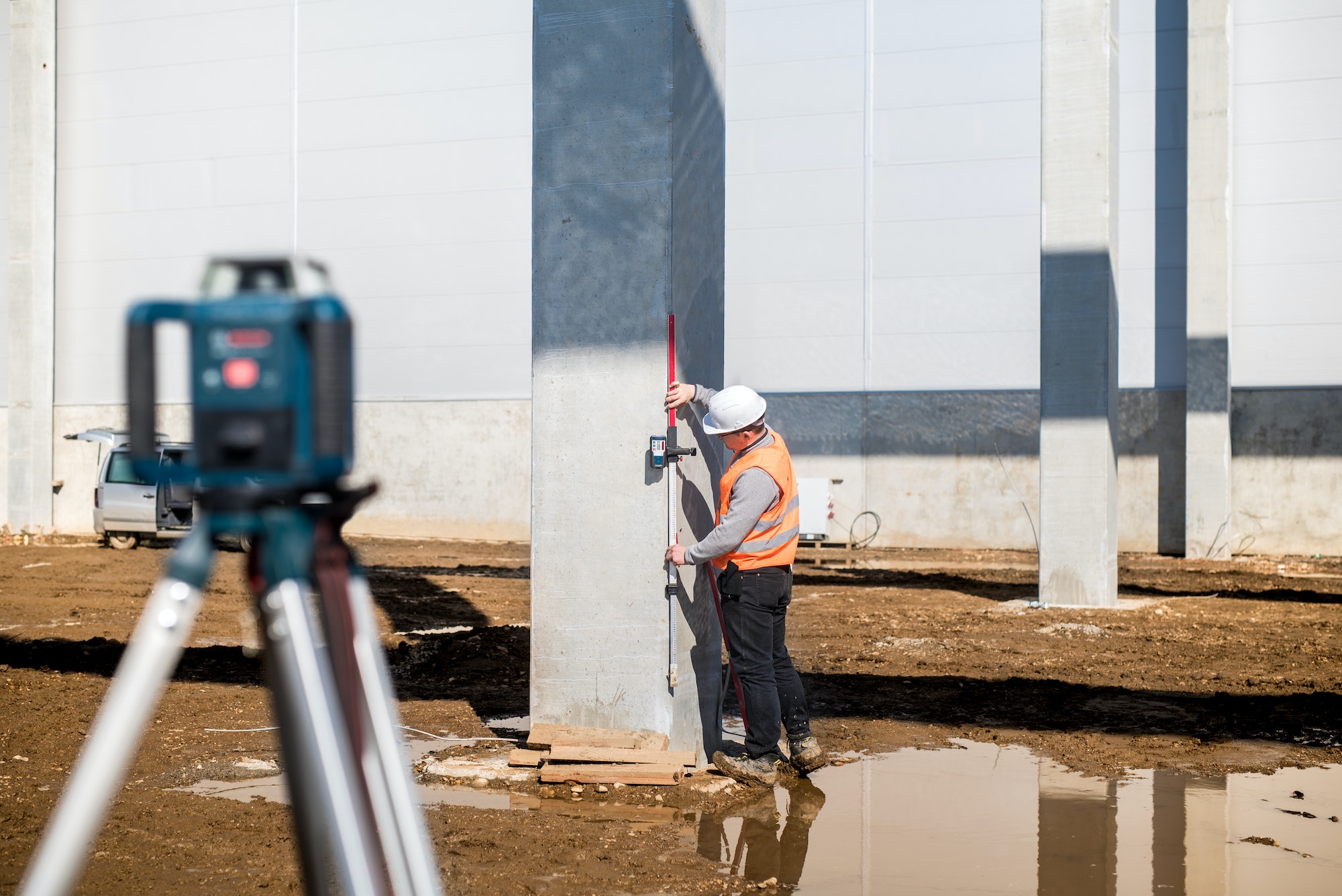 Professional surveyor using gps system and theodolite for correct level on construction site