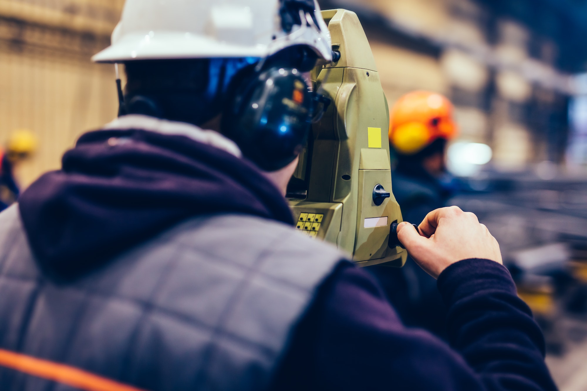 Surveyor doing measures in a factory.
