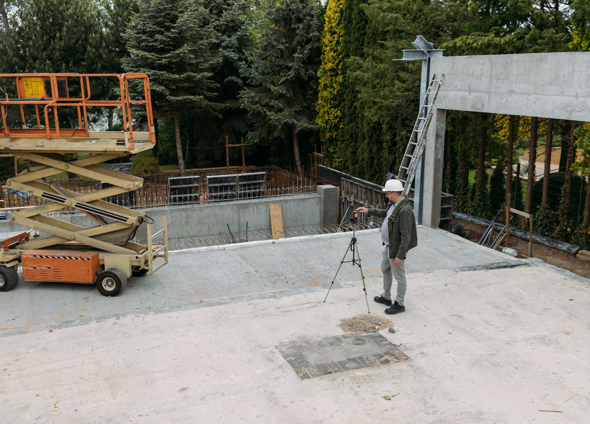 Surveyor engineer using geodetic equipment at construction site